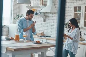 skön ung par framställning frukost tillsammans medan utgifterna tid i de inhemsk kök foto