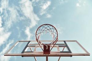 utomhus roligt. skott av basketboll ring med himmel i de bakgrund utomhus foto