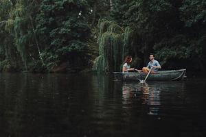 sorglös dag tillsammans. skön ung par leende medan njuter romantisk datum på de sjö foto