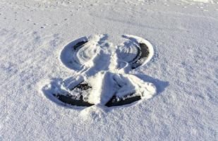 skriva ut av en snö ängel på färsk vit snö och frysta sjö. abstrakt, vinter- roligt foto