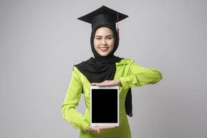 ung leende muslim kvinna med hijab bär gradering hatt, utbildning och universitet begrepp foto