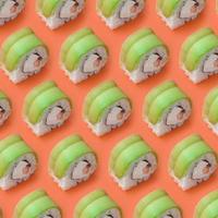 vegetarian sushi rullar med avokado och philadelphia ost på orange bakgrund. minimalism topp se platt lägga mönster med japansk mat foto