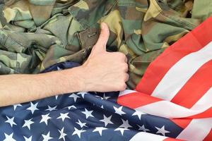 hand visar tummen upp på amerikan flagga och militär enhetlig foto