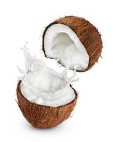 kokosnötter med mjölkstänk på vit bakgrund. foto