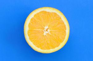 topp se av en ett orange frukt skiva på ljus bakgrund i blå Färg. en mättad citrus- textur bild foto
