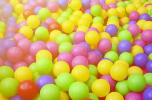 många färgrik plast bollar i en ungar' bollhav på en lekplats. stänga upp mönster foto