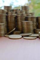 stor belopp av skinande ukrainska gammal 1 hryvnian mynt stackar stänga upp på trä- tabell på grön träd bakgrund. de begrepp av företag och rik liv i ukraina foto