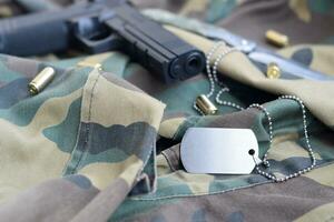 armén hund märka tecken med 9mm kulor och pistol lögn på vikta kamouflage grön tyg foto