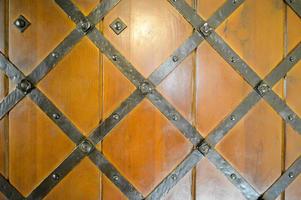 textur av gammal gammal medeltida antik kraftig trä- naturlig tjock dörr med nitar och naglar mönster och lås tillverkad av trä- plankor. de bakgrund foto