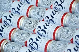 Kharkov, ukraina - december 9, 2020 många burkar av budweiser lageröl alkohol öl lögner på camo yta. budweiser är varumärke från anheuser-busch inbev mest populär i Amerika foto