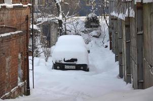 Kharkov, ukraina - december 4, 2016 en parkerad bil under en tjock lager av snö. konsekvenser av en stark och oväntat snöfall i ukraina foto