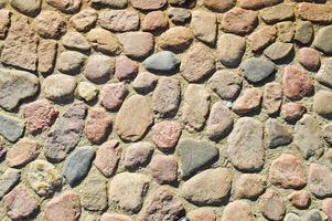 de textur av de sten väg, trottoar, väggar av stor grå gammal medeltida runda stark stenar, kullerstenar. de bakgrund foto