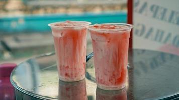 två glasögon av vattenmelon juice blandad med färsk sötad komprimerad mjölk foto