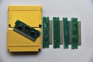 elektronisk patron styrelse för retro spel trösta. en gul plast patron på en svart bakgrund och ett elektronisk styrelse. foto