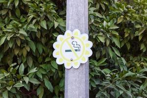 Nej rökning tecken i de form av en blomma i en parkera med en grön bakgrund foto