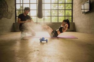 asiatisk manlig och kvinna boxning utbildare med sandsäckar i de Gym. foto