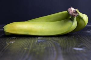 grön omogen bananer på de tabell foto