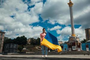 ung kvinna med nationell flagga av ukraina på de gata foto