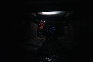 kvinna grävare med ficklampa utforskar de tunnel foto