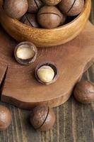 oskalade macadamia nötter på en trä- tabell foto