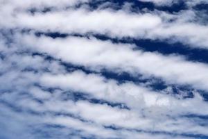 vackra fluffiga vita molnformationer på en djupblå sommarhimmel foto