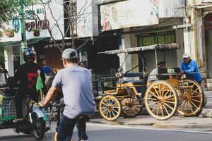 yogyakarta, indonesien på oktober 23, 2022. andong eller hästdragen transport med dess kusk parkerad på jalan malioboro, väntar för passagerare. foto
