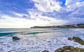 skön surfare vågor stenar klippor på strand puerto escondido Mexiko. foto