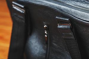 handgjort svart läder väska på en trä- bakgrund, tillverkad av naturlig material. foto