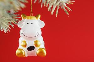vit oxe, röd ljus och jul träd gren på en röd bakgrund, en tjur som en symbol foto