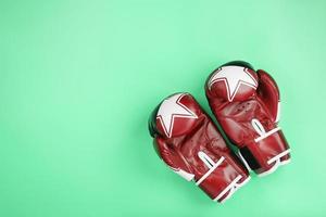 boxning röd handskar på en grön bakgrund, fri Plats. foto