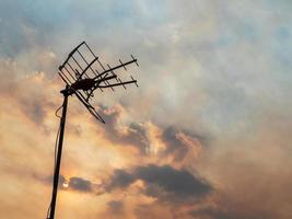 tv antenn på de bakgrund av en skön molnig kväll himmel foto