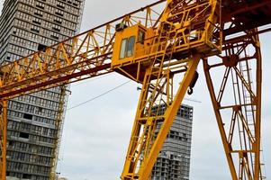 hög tung gul metall järn bärande konstruktion stationär industriell kraftfull brygga kran av bro typ på stöder för lyft frakt på en modern konstruktion webbplats av byggnader och hus foto