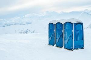 bärbar tre blå toaletter för skidåkare åka skidor tillflykt klienter på topp av berg i gudauri vinter- åka skidor tillflykt foto