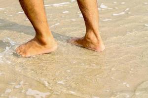 mänsklig fötter gående på de strand, turist koppla av på sommar Semester. foto