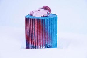 stänga upp lyx kaka täckt med blå och röd beläggning med vit bakgrund foto