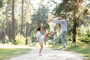 ung par i kärlek har roligt och njuter de skön sommar natur. kvinna och man, bär i denim utrusta är har datum utomhus i de parkera. romantisk relation. valentines dag foto