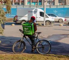 dnepropetrovsk, ukraina - 02.09.2022 en leverans service kurir med en termisk väska på en cykel rider runt om de stad. Hem mat leverans. foto