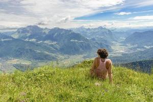 kvinna sitter på klippan och tittar på landskapet foto