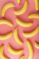 geometrisk mönster av bananer på en rosa bakgrund. de se från de topp. foto