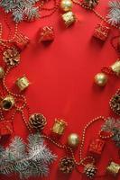 jul dekorationer med gran grenar på en röd bakgrund med fri Plats. foto