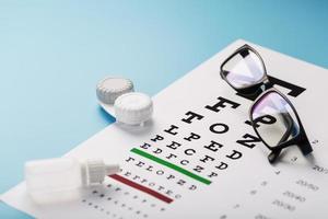 syn checkar och förebyggande, glasögon, linser och droppar för syn korrektion på en blå bakgrund foto