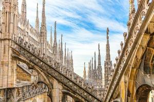 taket på katedralen i milano duomo di milano med gotiska spiror och statyer i vit marmor. topp turistattraktion på piazza i Milano, Lombardiet, Italien. vidvinkelvy av gammal gotisk arkitektur och konst. foto