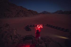 resande drömmare äventyrare i wadi rom öken- på natt ljus målning ord jordan med hjärta. resa utforska jordan äventyr begrepp foto