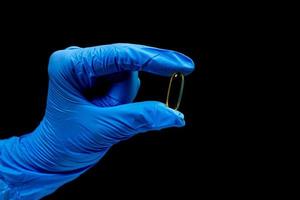medicinsk piller på isolerat svart bakgrund med reflexion i hand foto