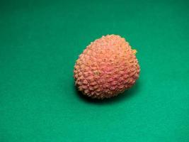 litchi på de tabell. kinesisk plommon på en grön bakgrund. mogen frukt från Asien. utsökt, saftig produkt. foto