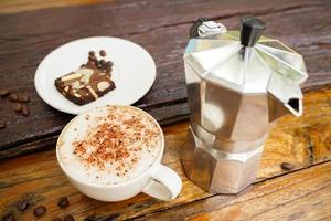 varm cappuccino i vit kopp med trä- bakgrund, kaffe är en populär dryck Allt över de värld. foto