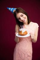 glad kvinna med kakan med ljus foto