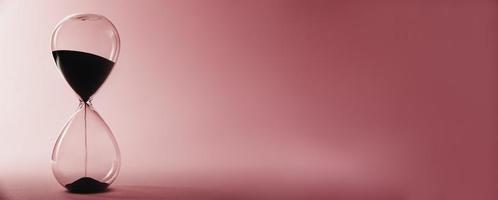 timglas på en rosa bakgrund, lång baner. brådskande karaktär och löpning ut av tid begrepp foto