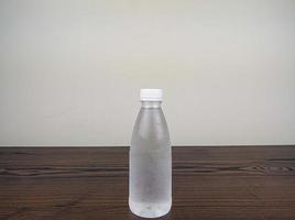 stänga upp kall plast dryck flaska på trä- tabell foto