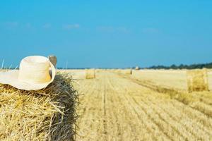 en ensam bondens hatt på en höstack i de fält efter en hård arbete foto